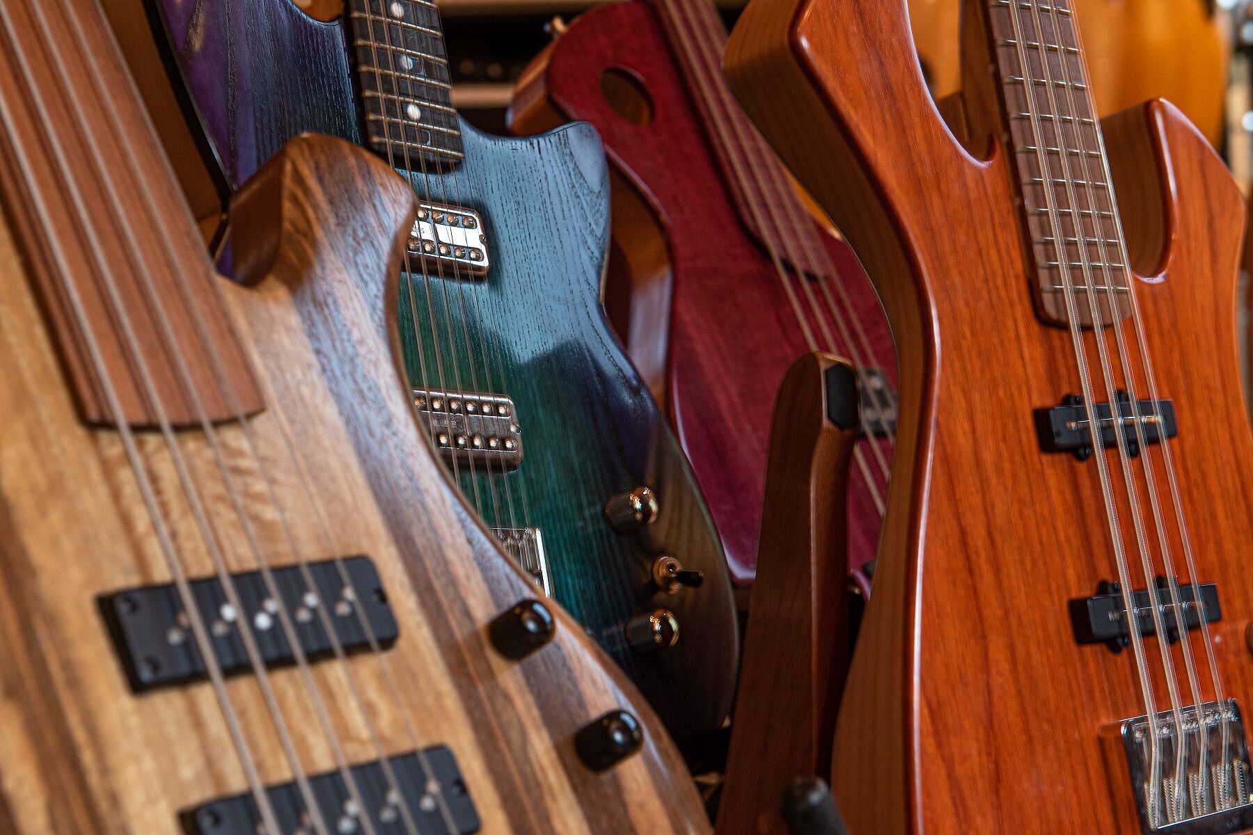 A selection of custom-made electric guitars and bass guitars made by Mac Ritchey/Possum Hall Instruments