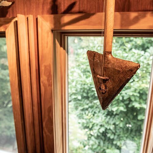 a moroccan gimbri hangs in front of a window