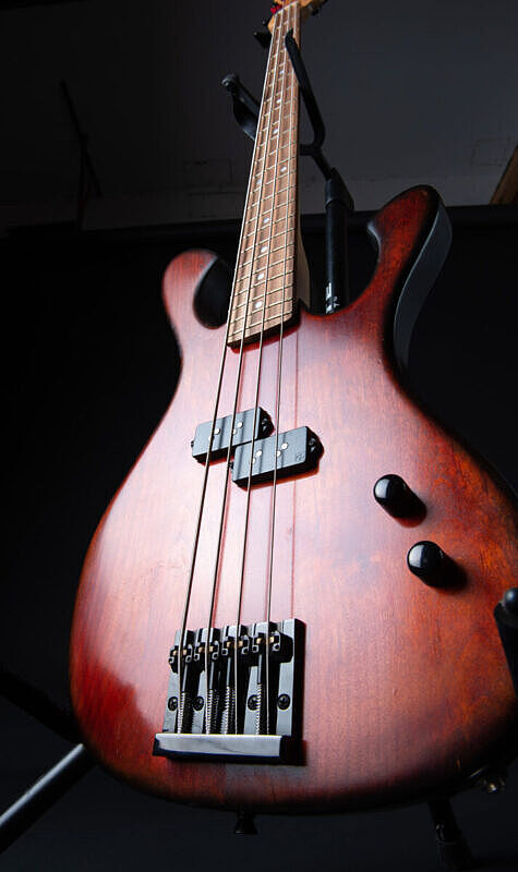 custom illusionist bass four string, red alder body, single p pickup body detail