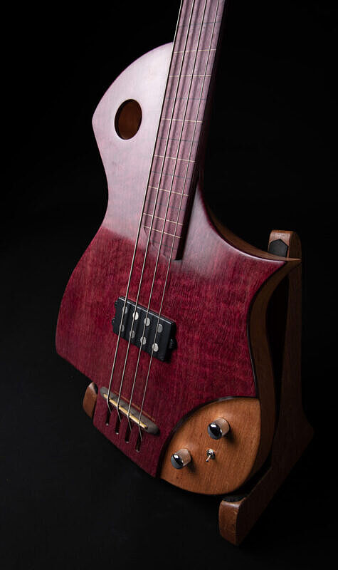 Picossum 4 string fretless bass half profile view, purpleheart top on spanish cedar, purpleheart fingerboard