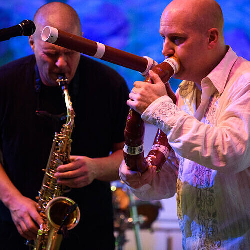 mac plays a circular didjeridu alongside a saxophonist